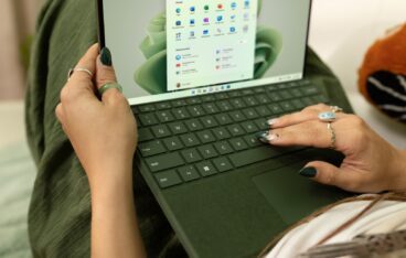 a woman using a laptop computer on a bed